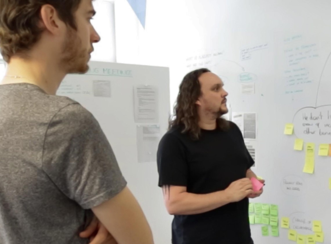 Colleagues collaborating using post its on a whiteboard