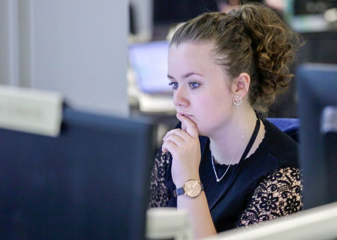 Woman looking thoughtfully at a computer monitor