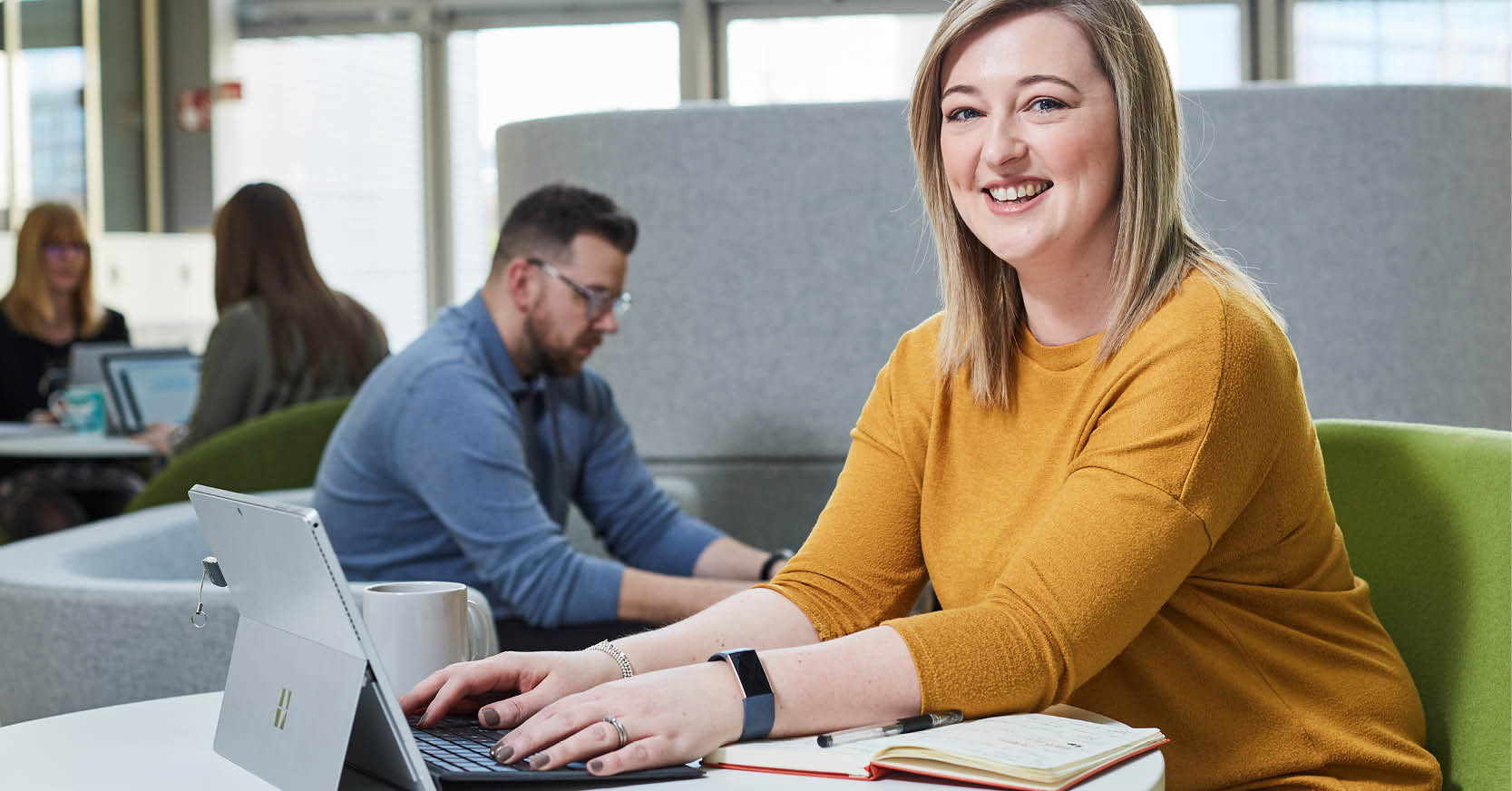 Woman working on a laptop in an open office space