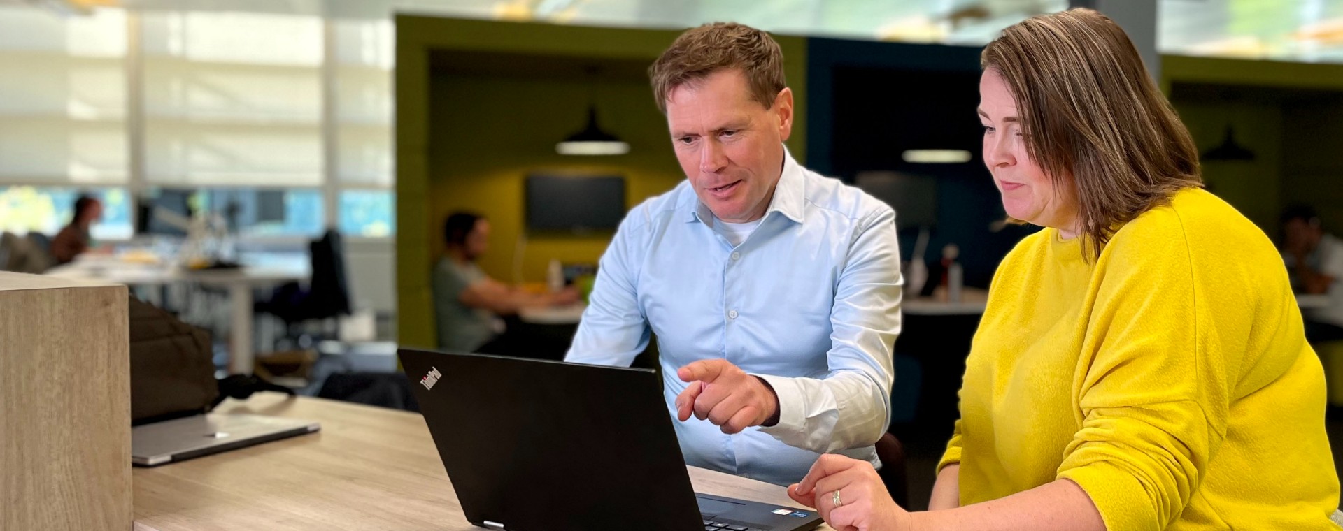 A man and a woman working together on a laptop.