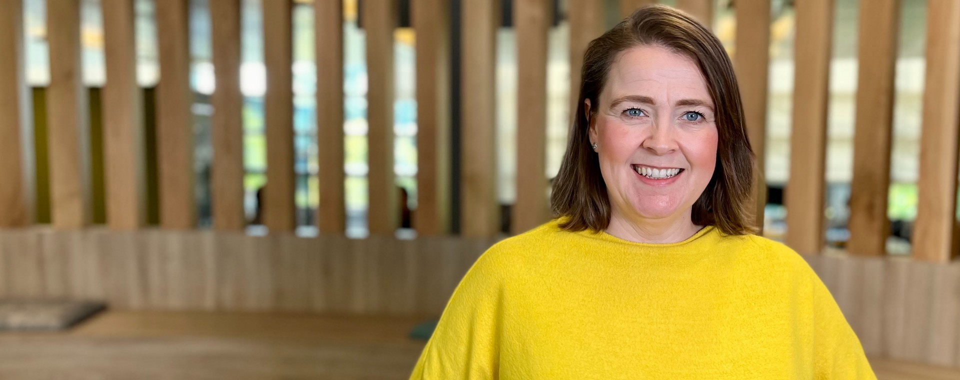 Woman in a yellow jumper, smiling